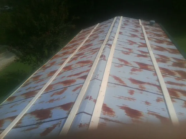 Rusted metal roof panels with new wood purlins before replacement — Storm Damage Roof Repair in Beardsley by Roofing Brothers