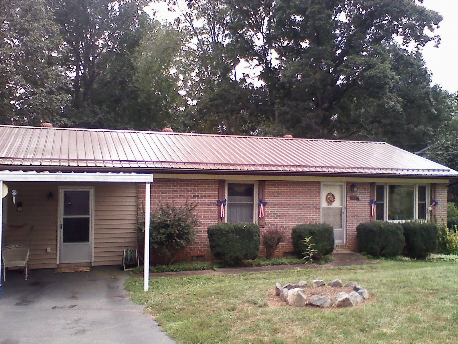 Bronze metal roof and carport on a brick ranch home — Roof Repair work by our crew in Beardsley
